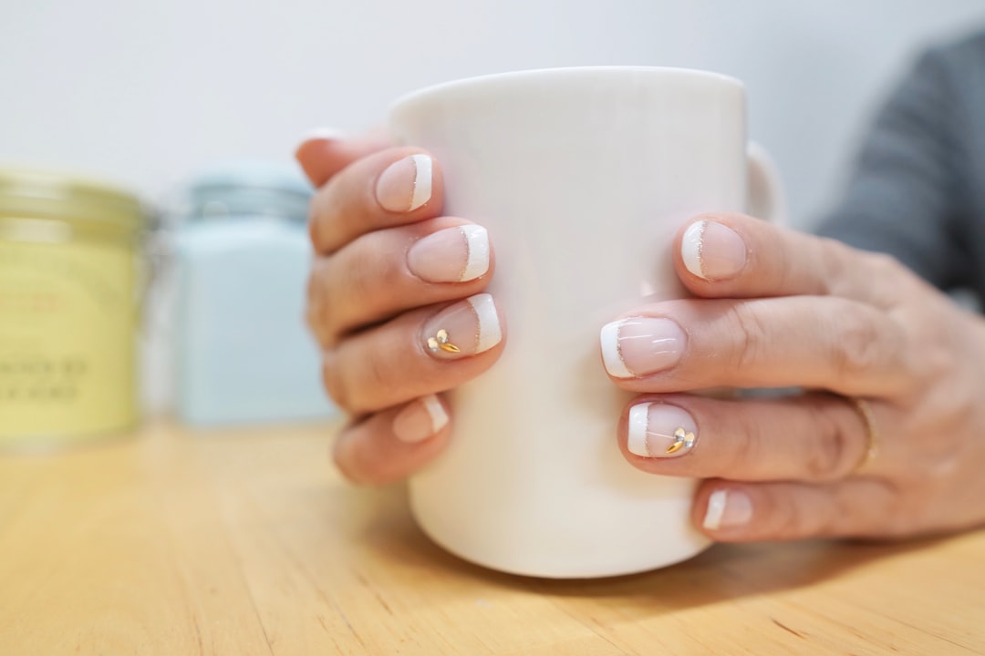 A gel manicure being finished in bright light