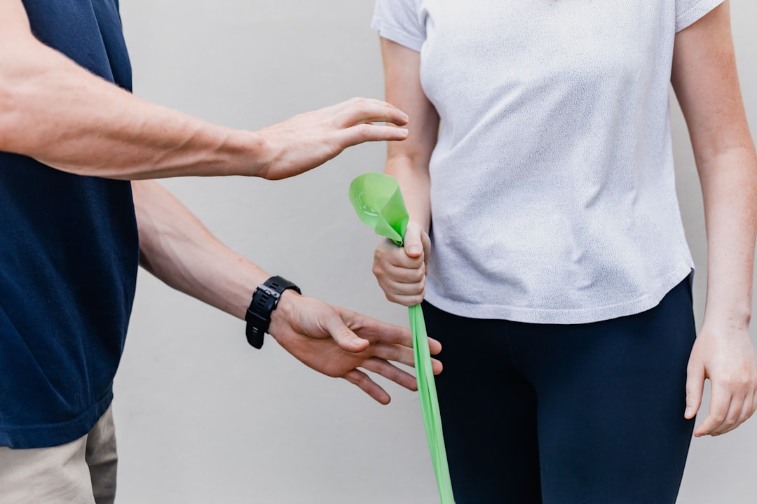 A coach guiding resistance-band work in a bright studio